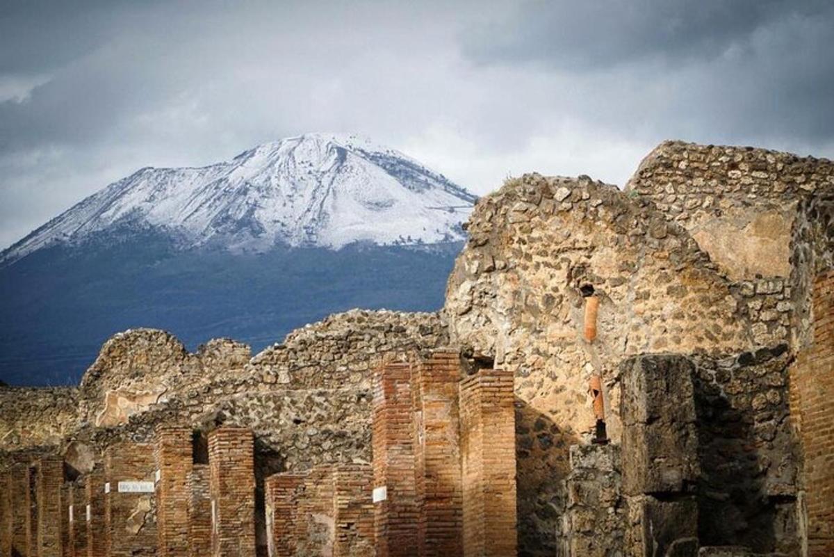 una montagna coperta di neve in lontananza dietro un vecchio edificio