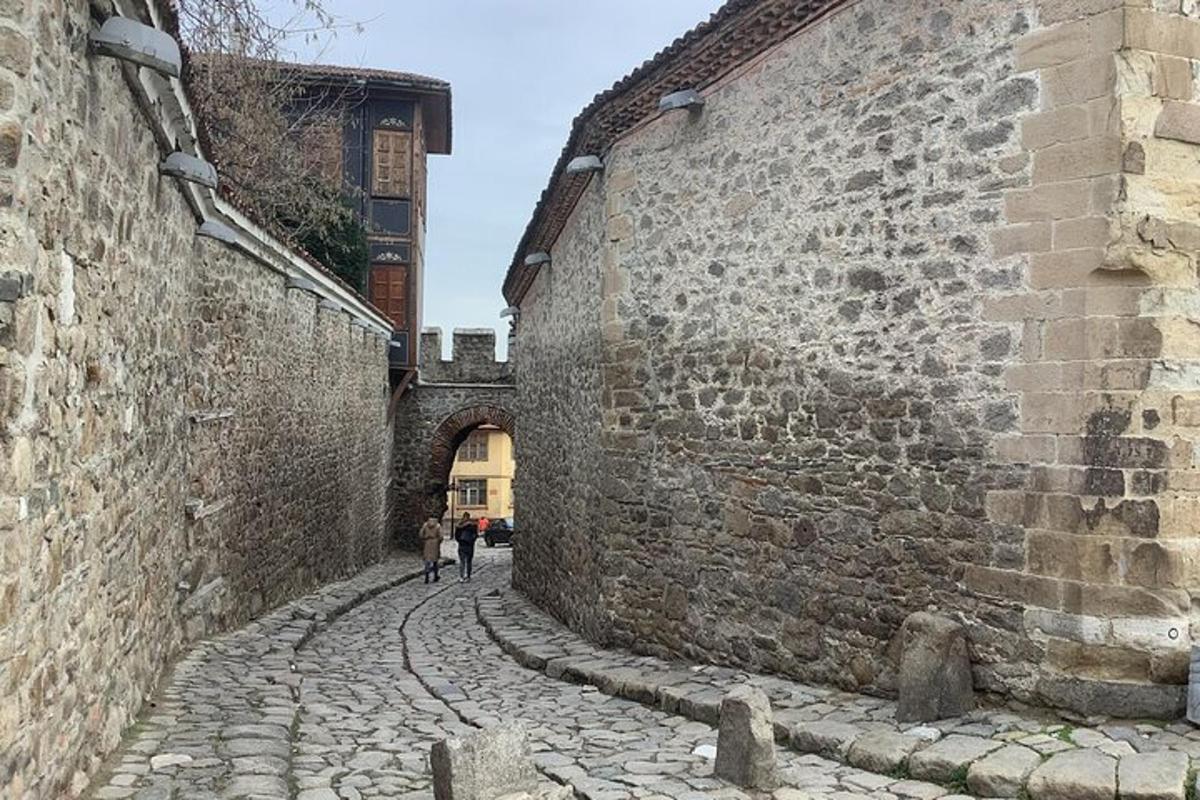 two people walking down an alley between two buildings