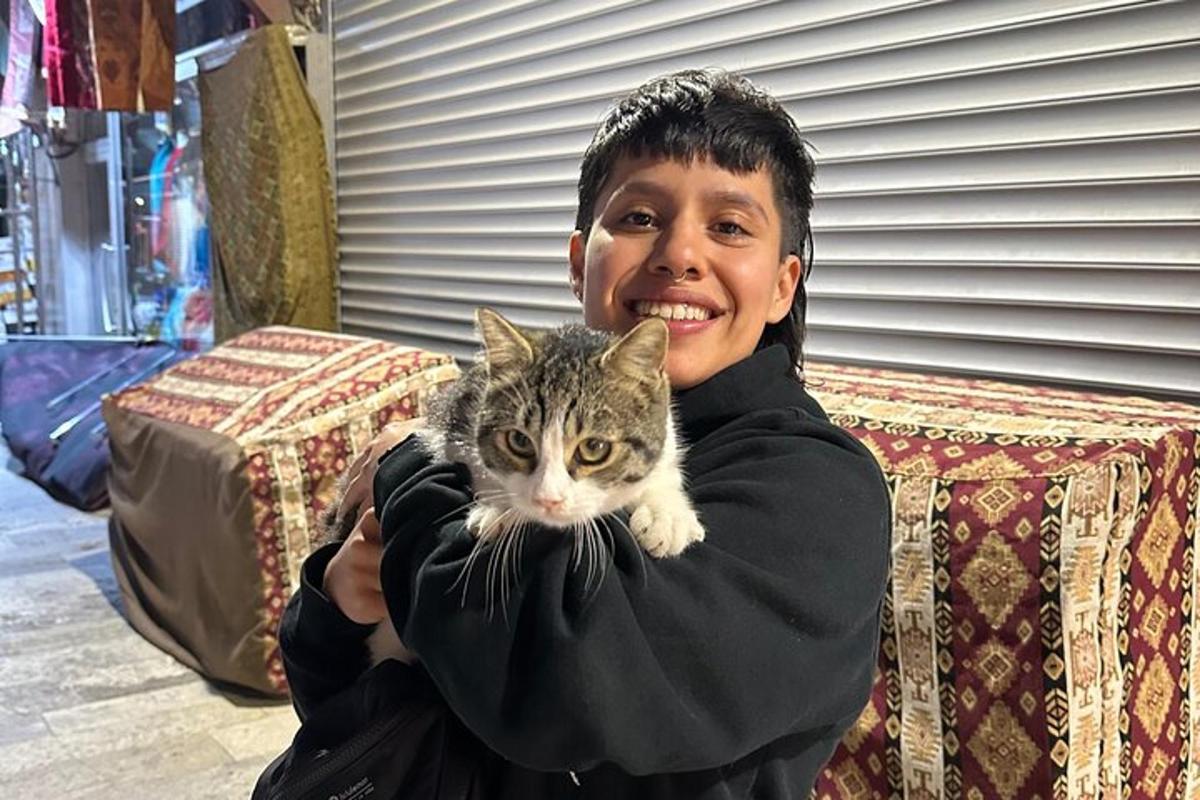 seorang gadis muda memegang kucing dalam pelukannya