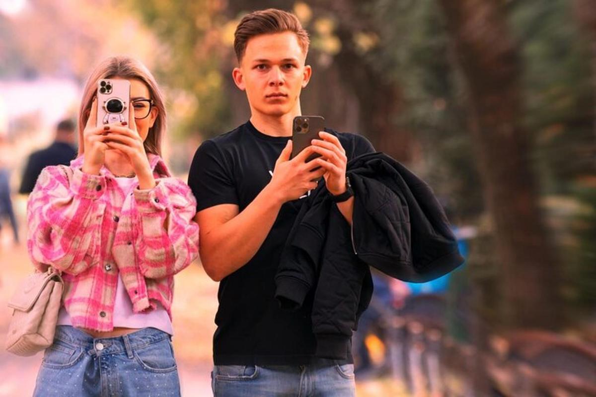 seorang lelaki dan seorang wanita mengambil gambar dengan telefon bimbit mereka