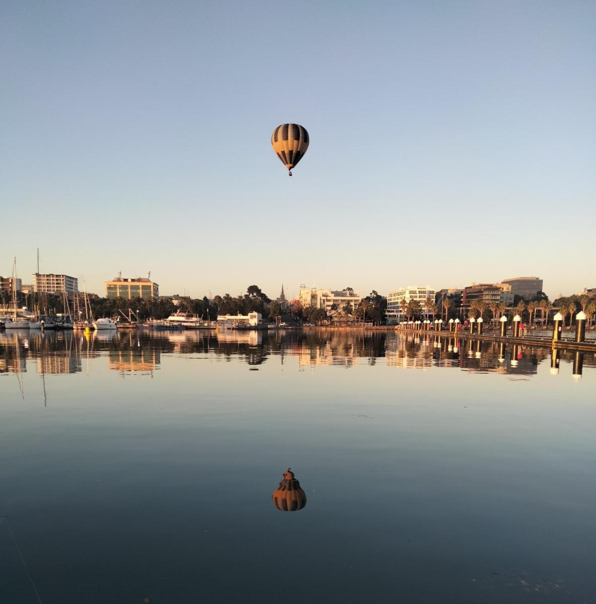 horkovzdušný balón letící nad vodní plochou