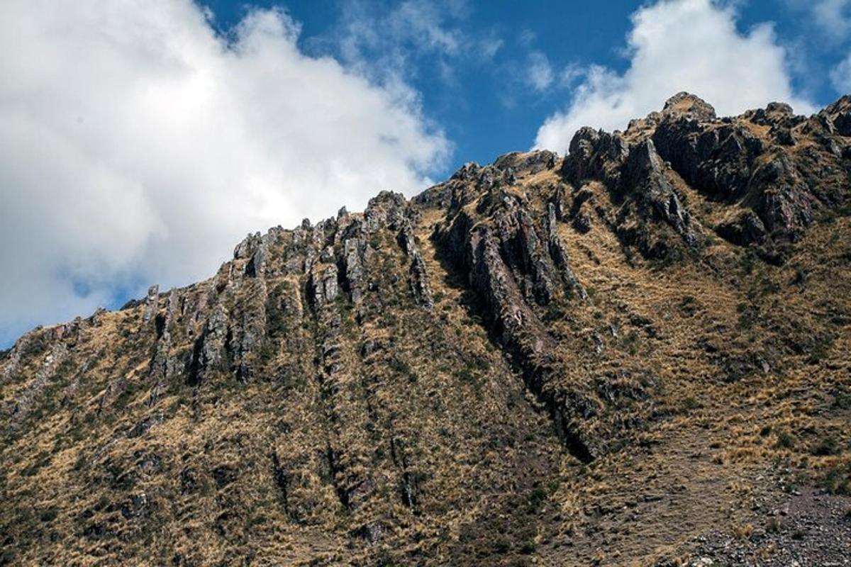 grýtt fjall með bláum himni og skýjum
