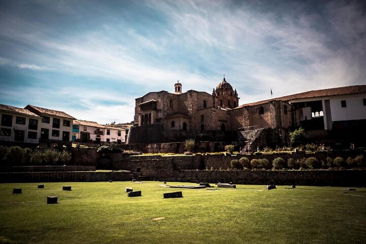 Un edificio antiguo en lo alto de un campo verde.