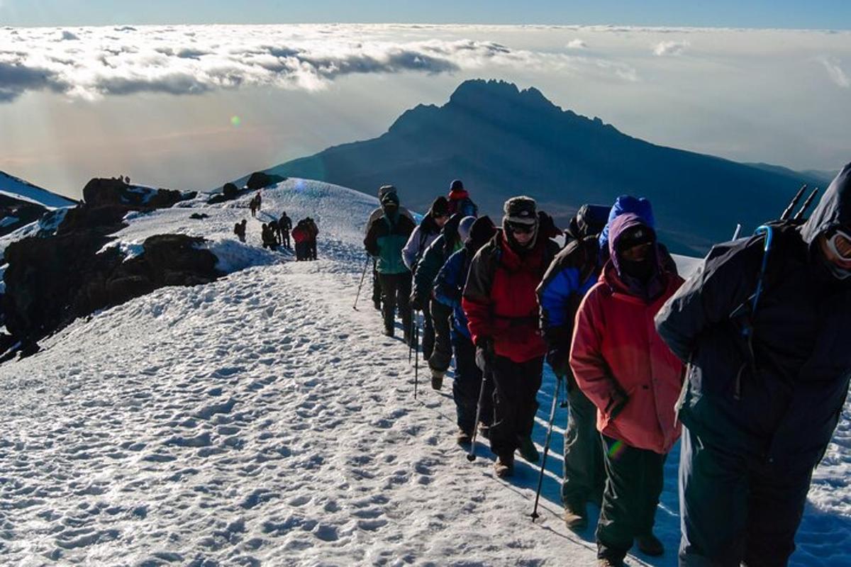 um grupo de pessoas subindo uma montanha coberta de neve