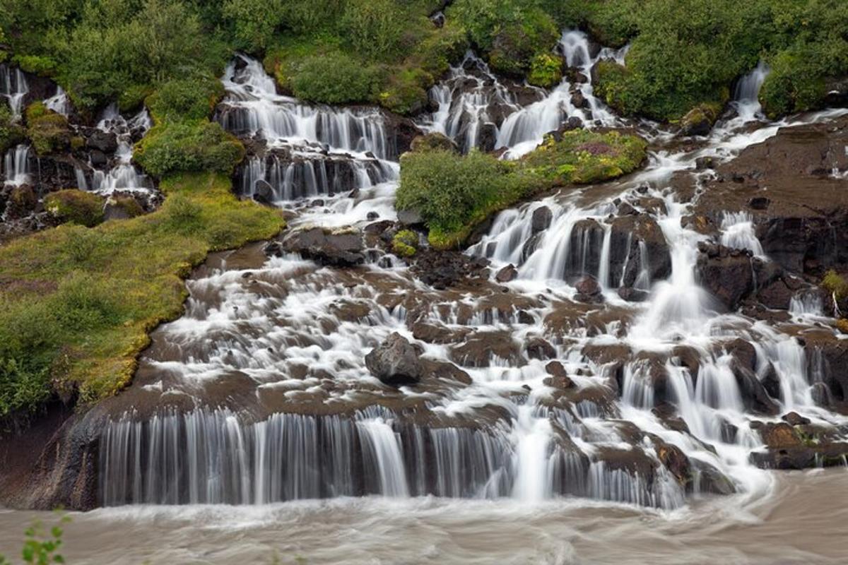 a group of waterfalls on the side of a river