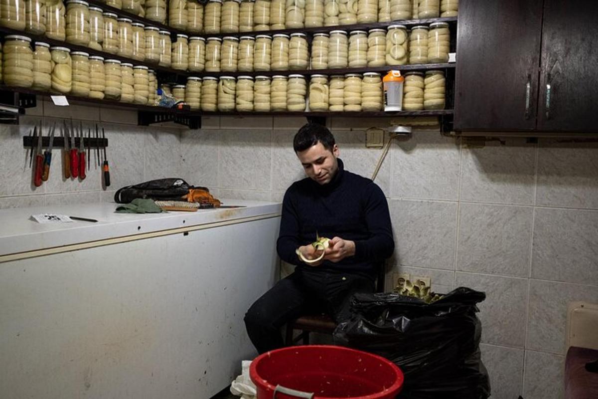 Ένας άντρας που κάθεται στην κουζίνα και τρώει ένα σάντουιτς