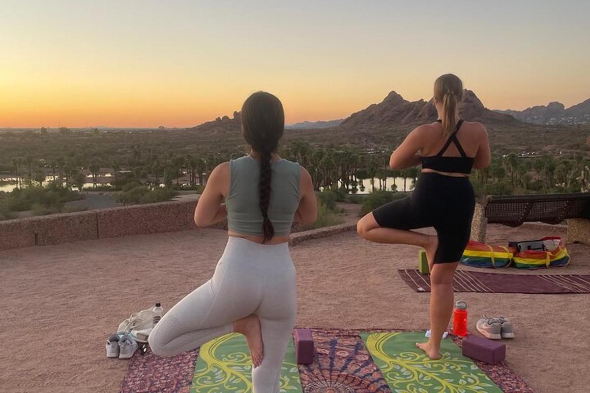 to kvinner som gjør yoga på toppen av et fjell
