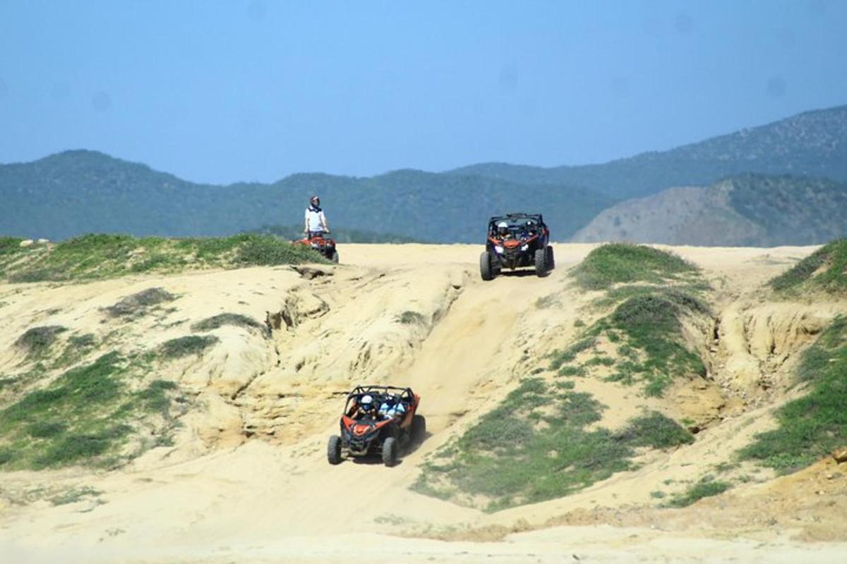 dues persones muntant quads a la sorra d'una platja