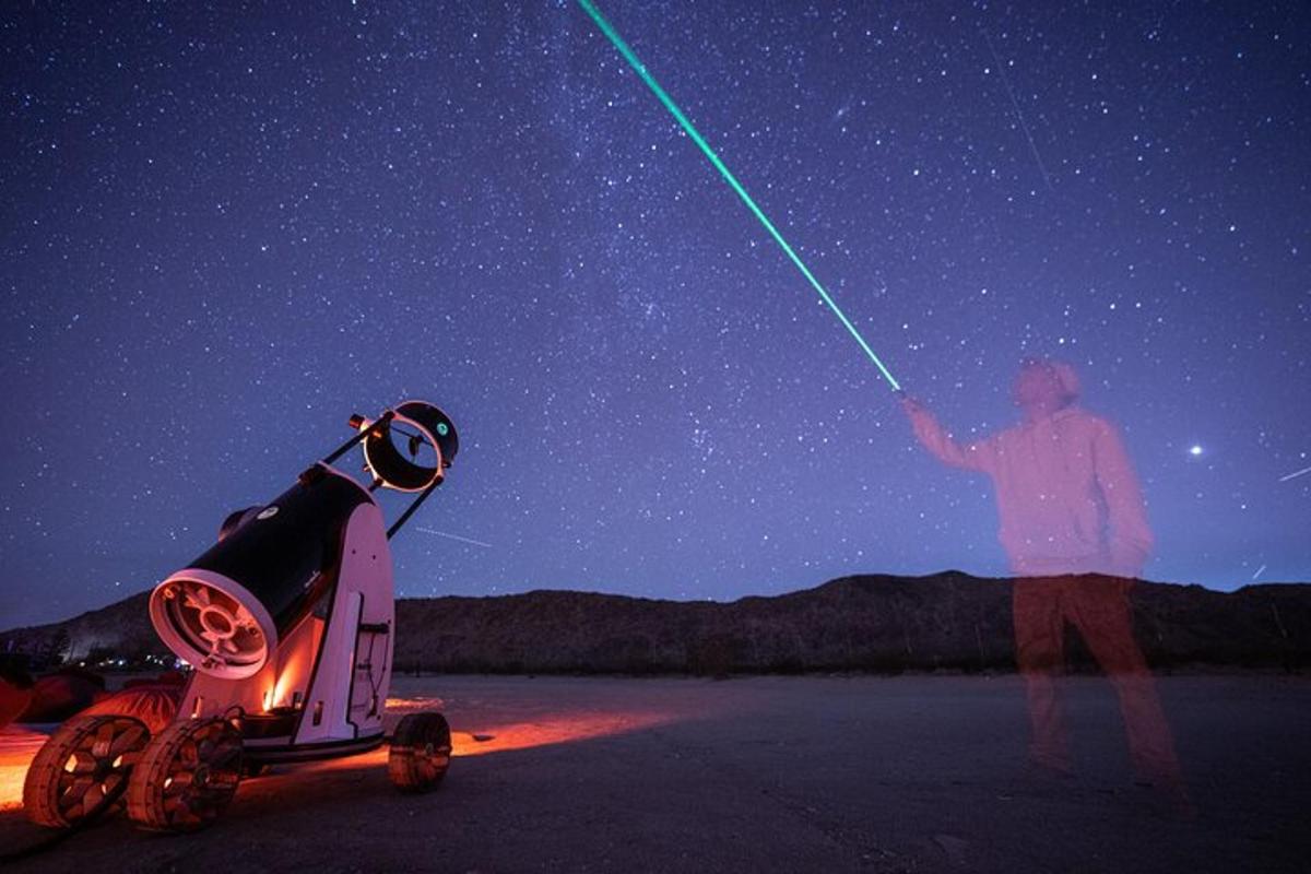 un uomo in piedi accanto a un cielo stellato con una spada laser verde