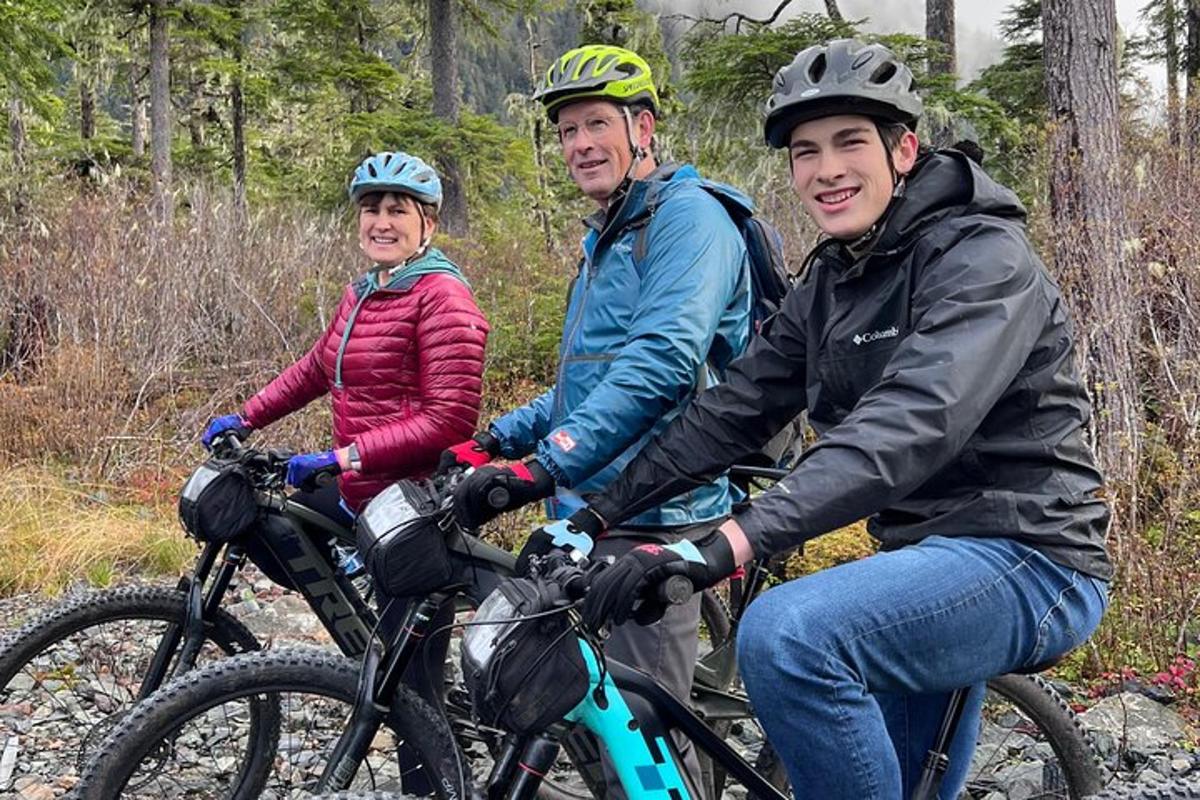 a group of three people riding bikes on a trail