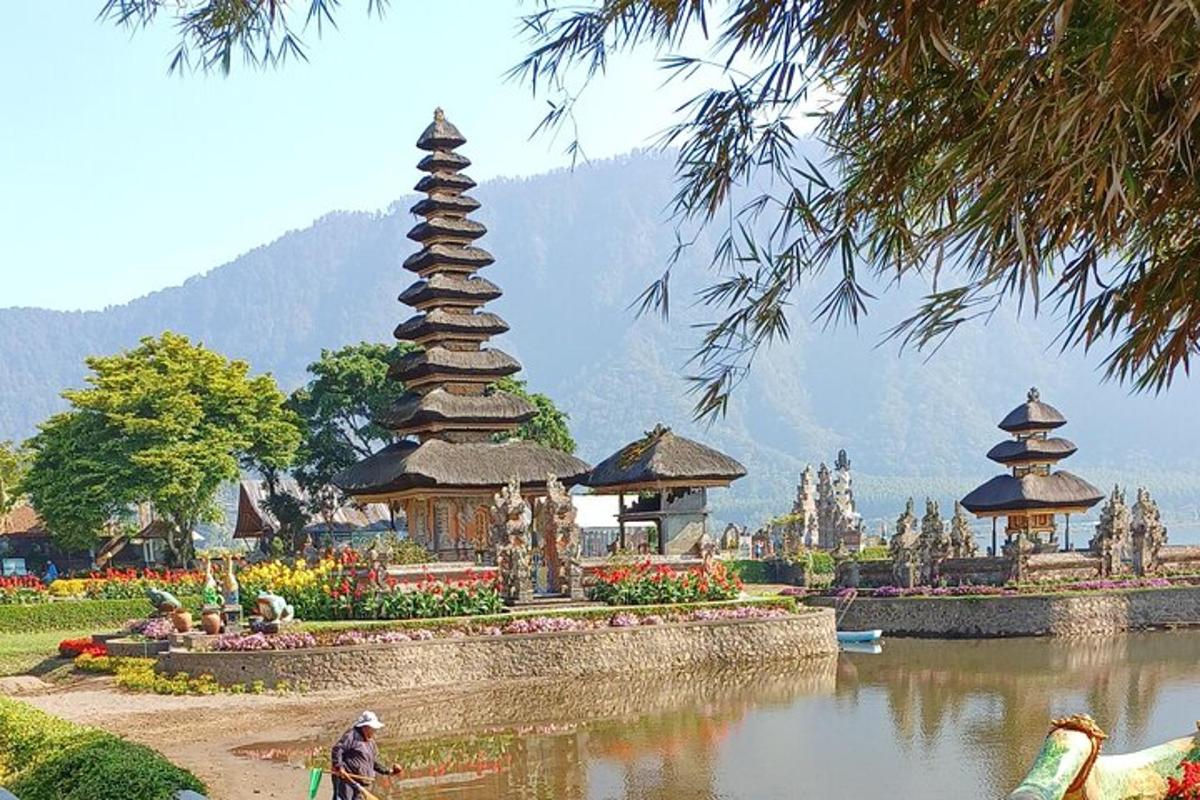 un uomo in bicicletta davanti a un lago con una pagoda