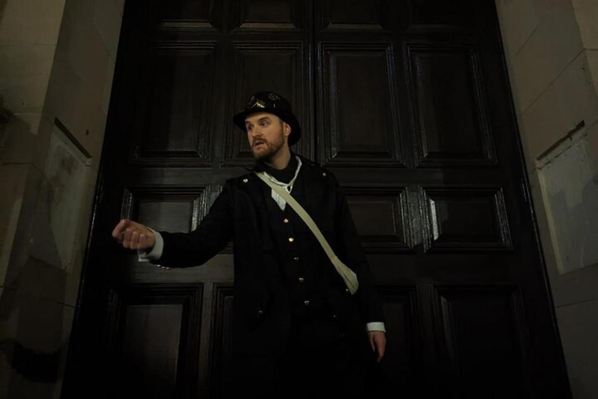 muž v uniformě stojící před dveřmi