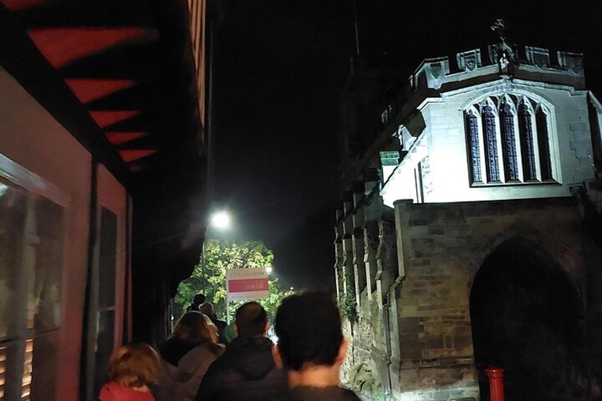 skupina lidí stojících v noci před budovou