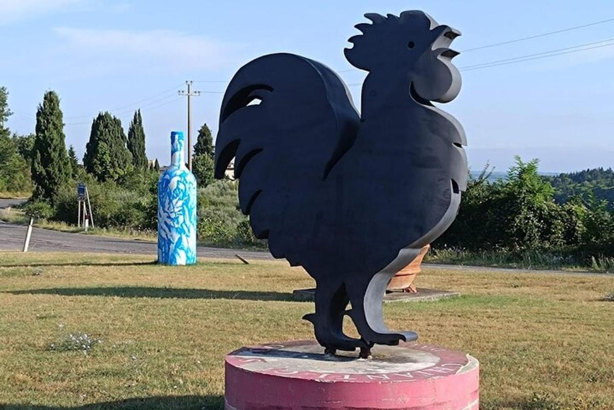 a statue of a chicken standing on top of a field