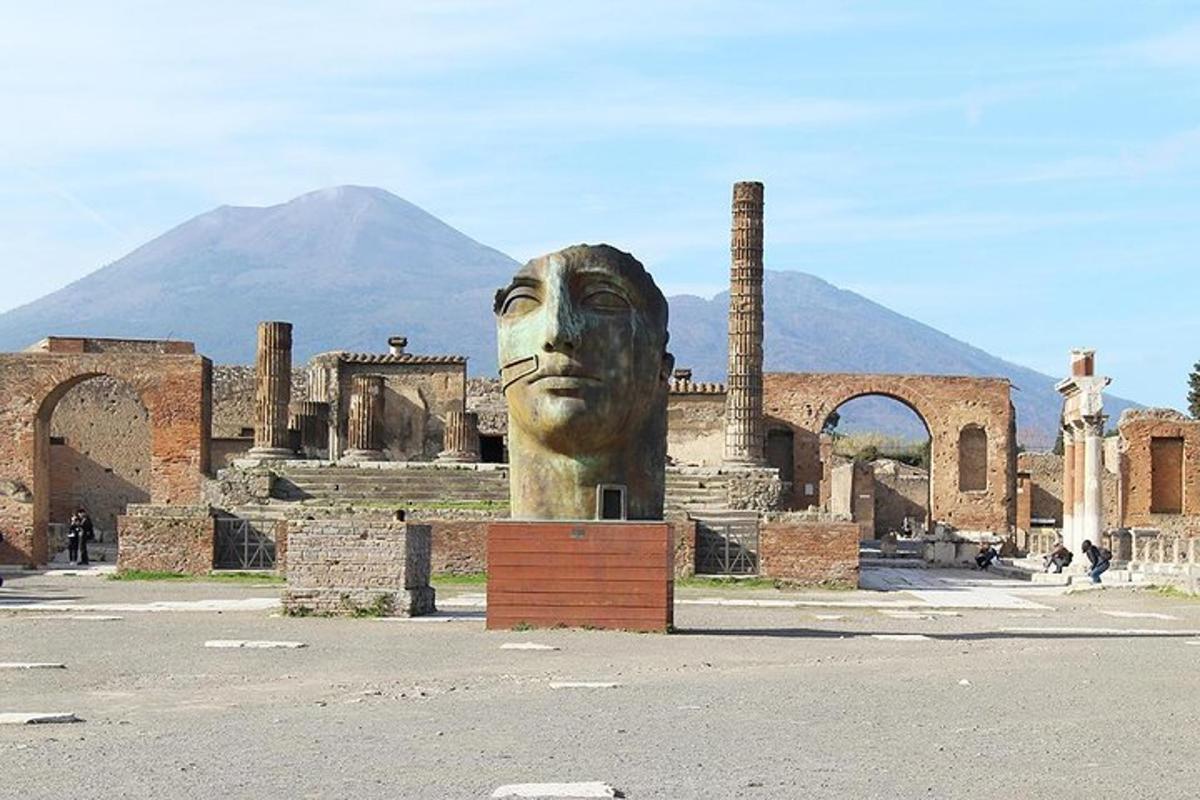 una gran estàtua d'un cap davant d'un edifici