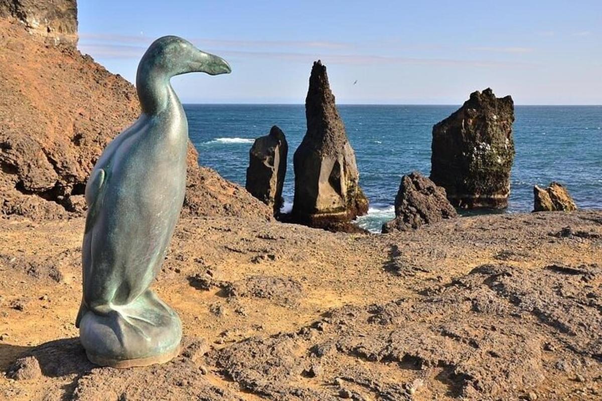 a statue of a bird sitting on a beach