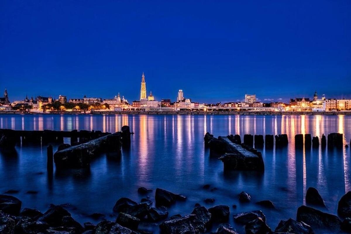 uno skyline della città di notte con rocce nell'acqua