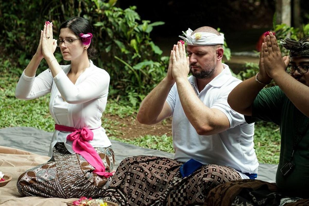 a man and a woman sitting on a blanket doing yoga