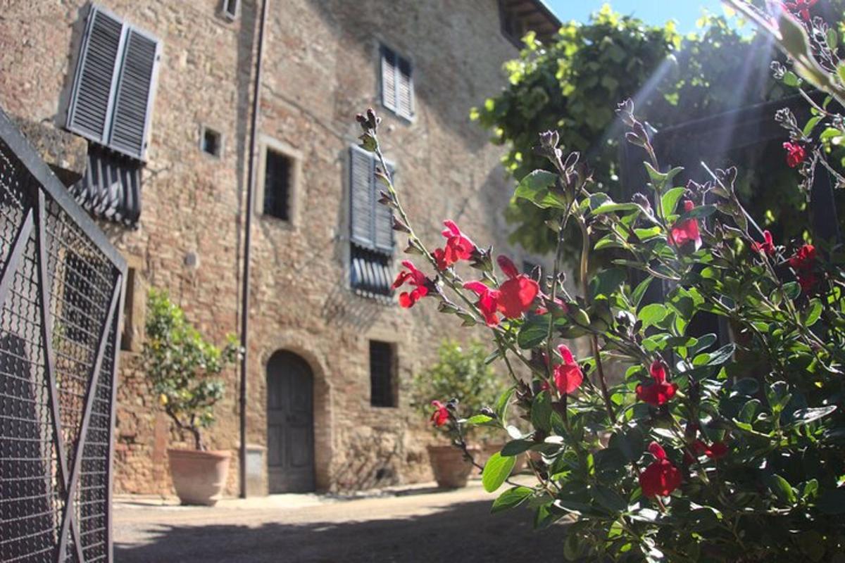 un edificio in pietra con fiori rossi di fronte