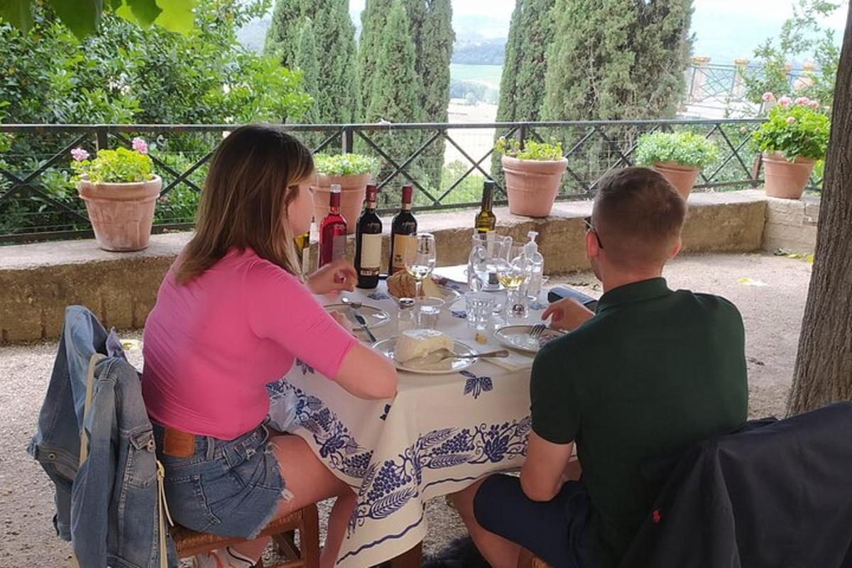 un uomo e una donna seduti a un tavolo con bottiglie di vino