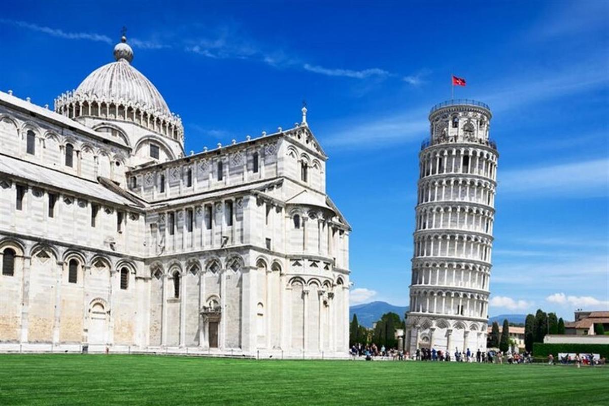 uma torre inclinada ao lado de um edifício com uma catedral
