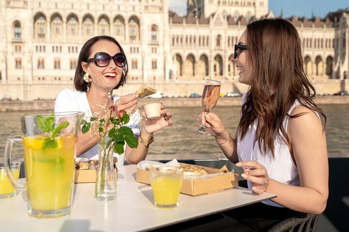 due donne sedute a un tavolo con cibo e bevande