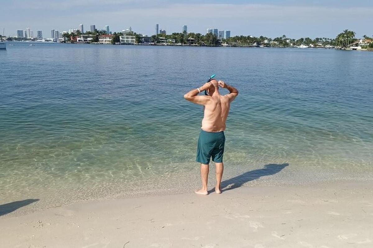 seorang pria berdiri di pantai sambil melihat air