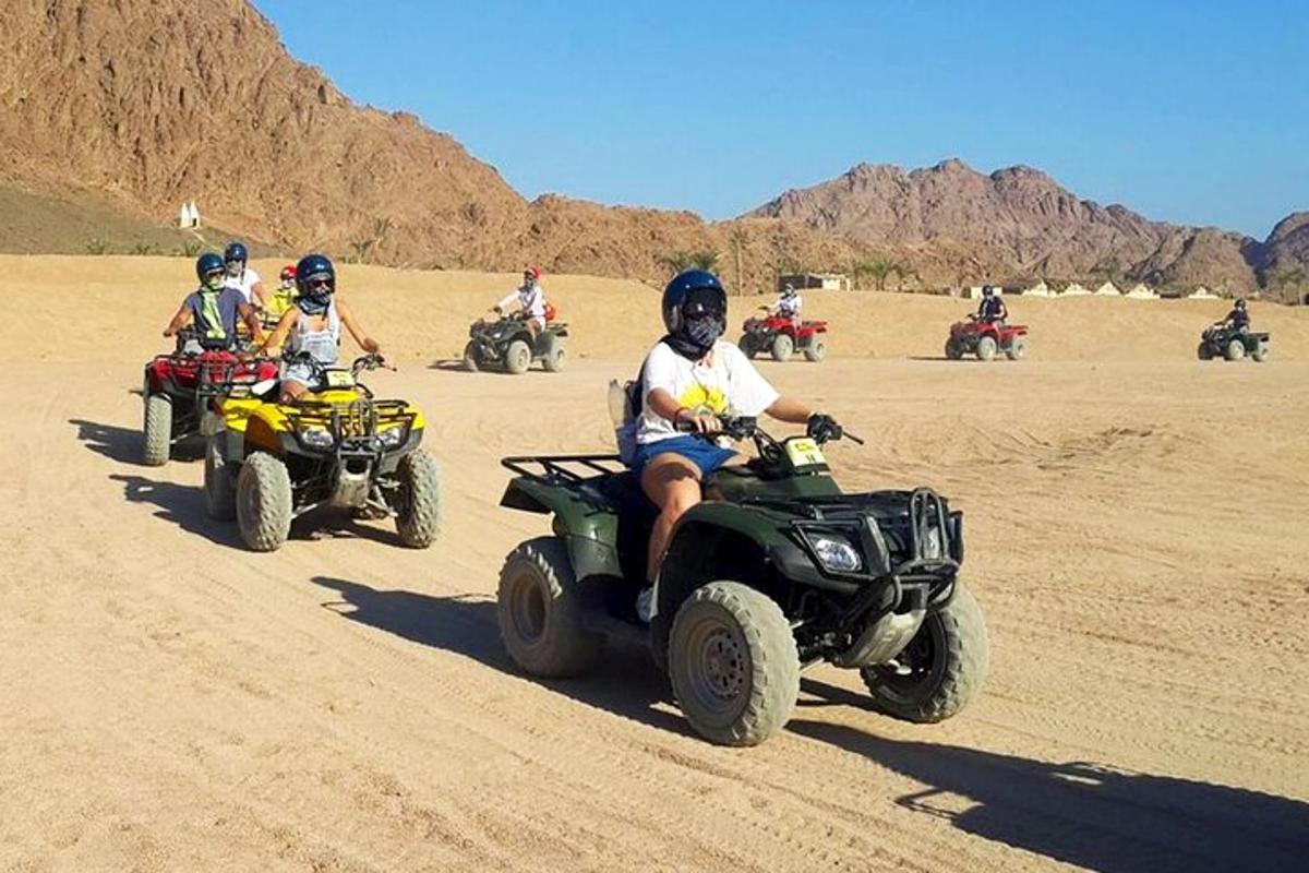 a group of people riding atvs in the desert