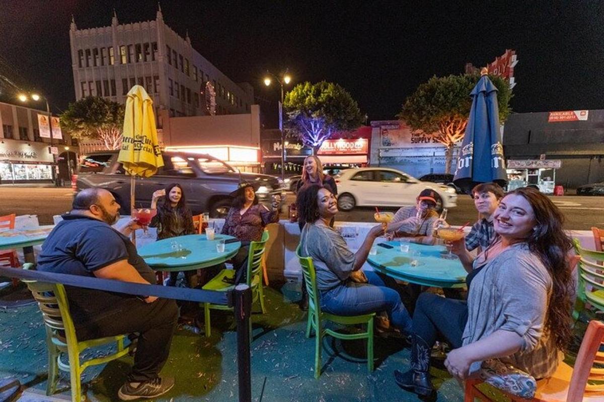 Un grupo de personas sentadas en mesas en un restaurante por la noche.
