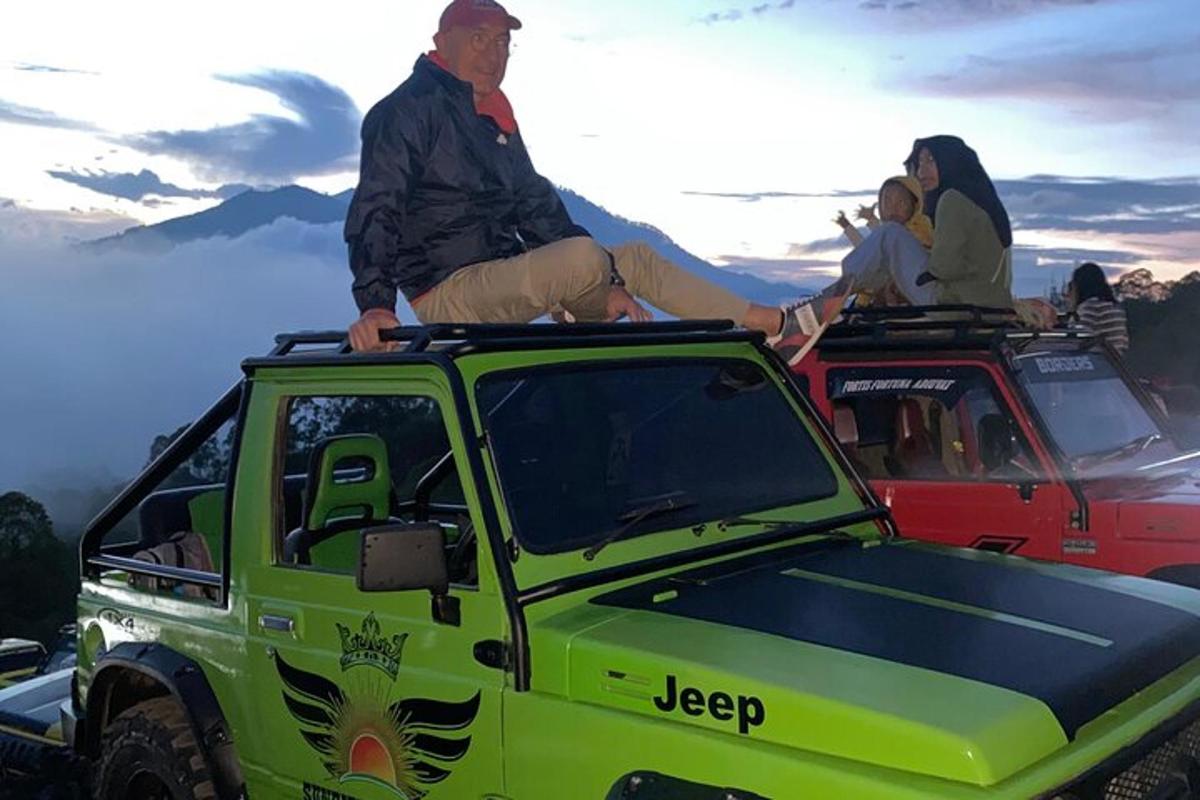 isang grupo ng mga tao na nakaupo sa bubong ng isang berdeng jeep