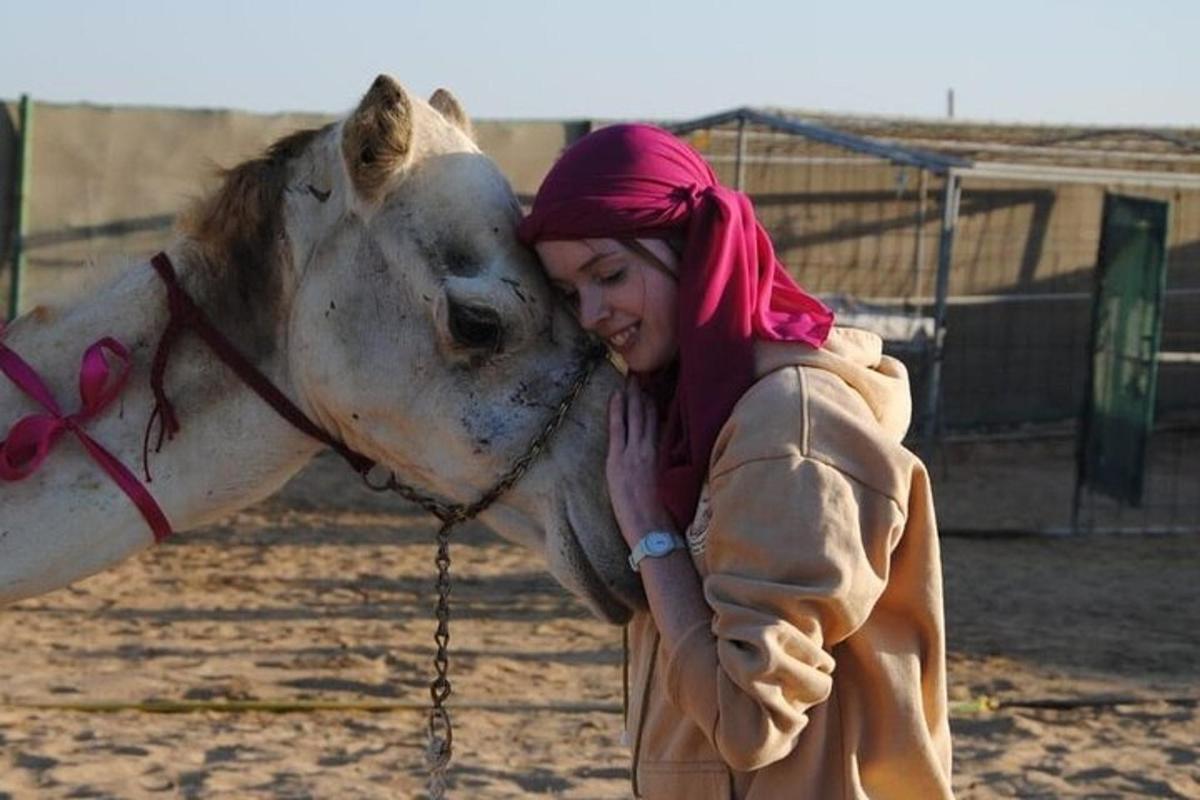 una mujer joven besando a un caballo