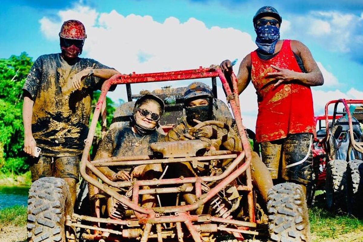 a group of people covered in mud standing next to a truck