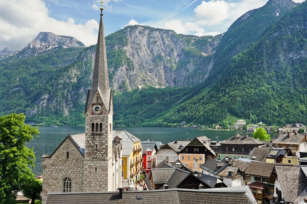 a church with a clock tower in front of mountains