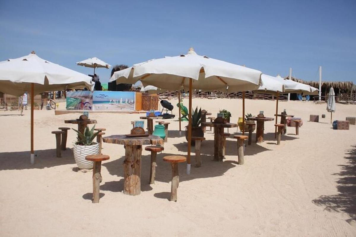 una fila di tavoli e sedie con ombrelloni sulla spiaggia