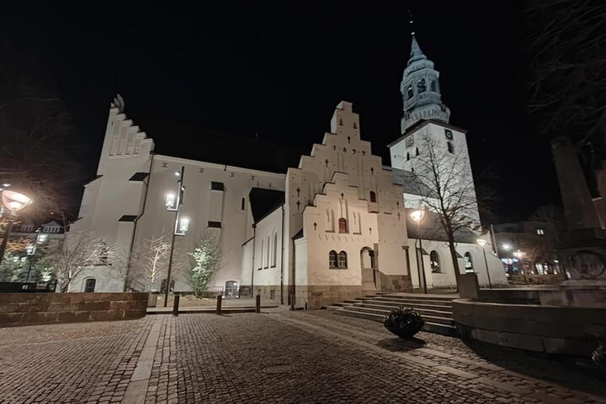 una grande chiesa bianca con una torre dell'orologio di notte