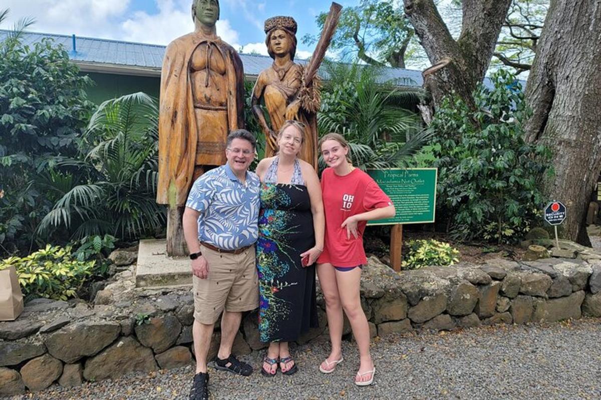 Trīs sievietes stāv statujas priekšā
