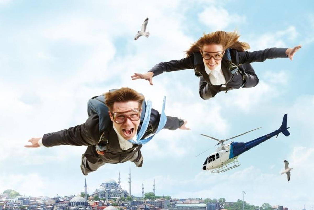 a man and a woman jumping in the air with a helicopter