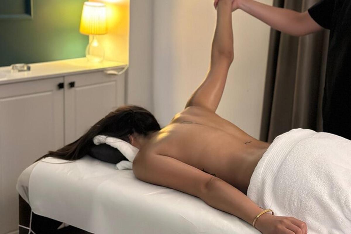 một người phụ nữ khỏa thân nằm trên giường trong phòng