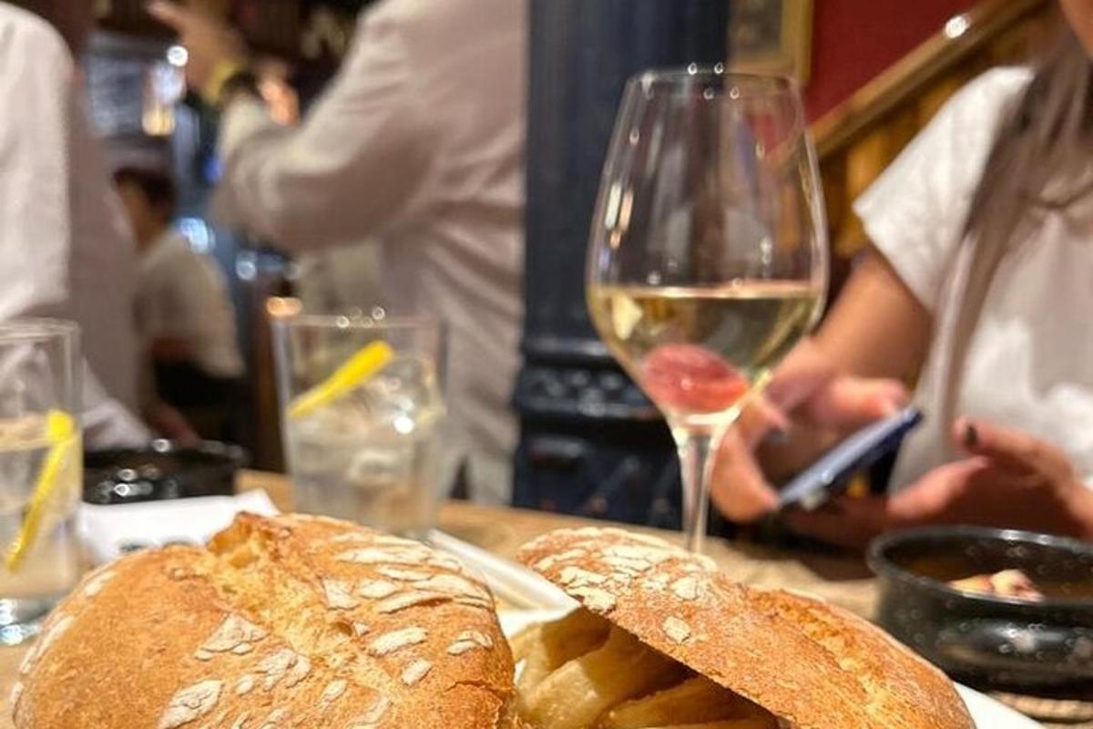 galds ar glāzi vīna un maizes klaipu