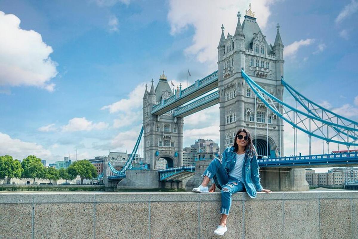 a woman sitting on a wall in front of a bridge