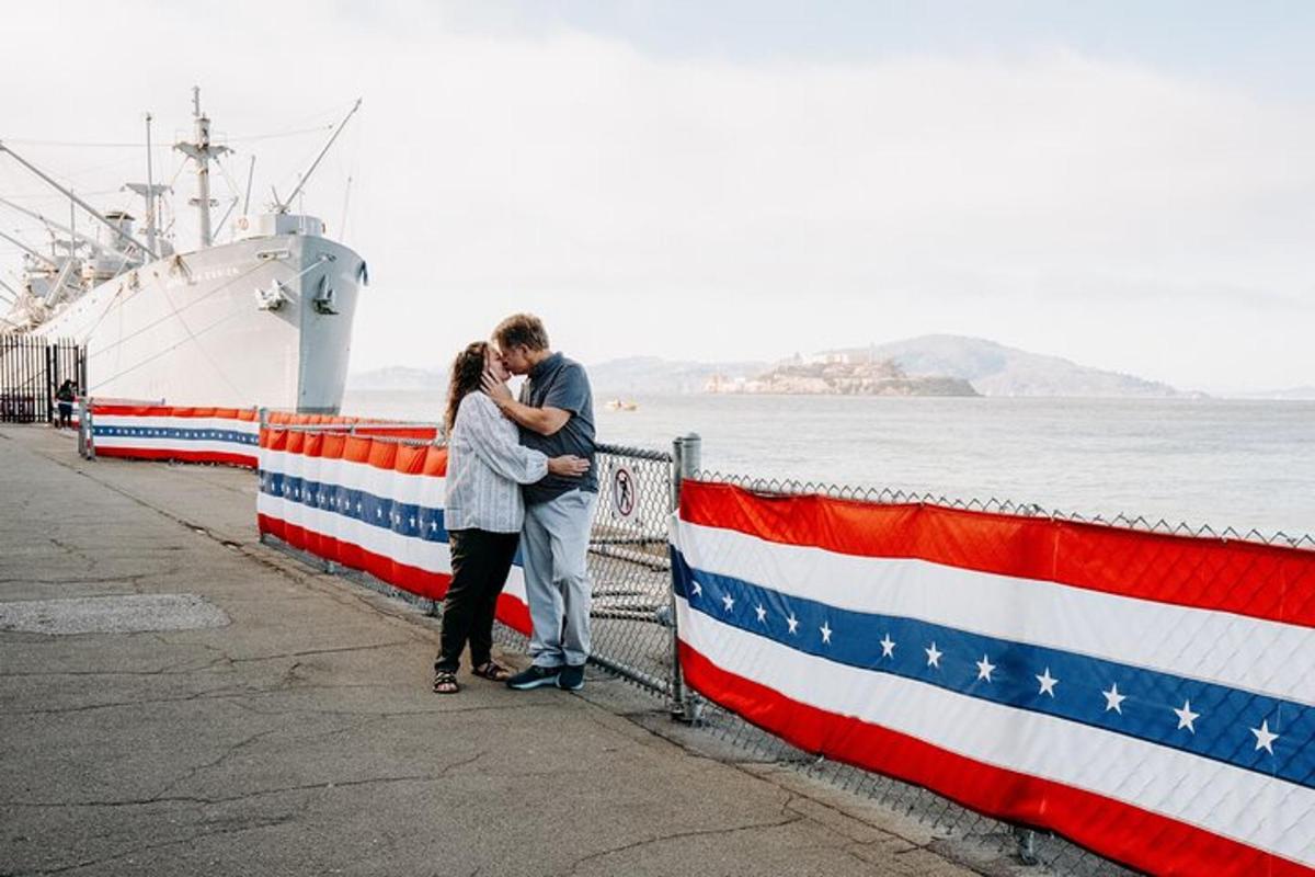 a man and woman standing next to a fence with an american flag