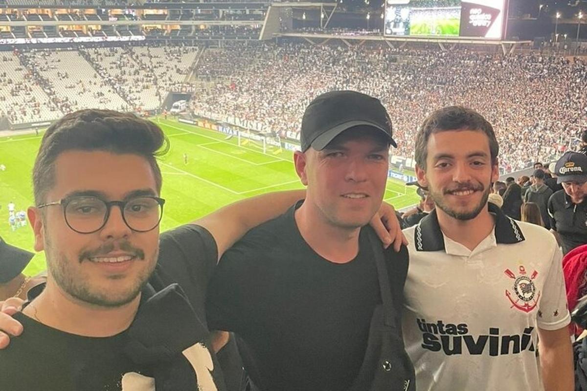 a group of three men posing at a soccer game