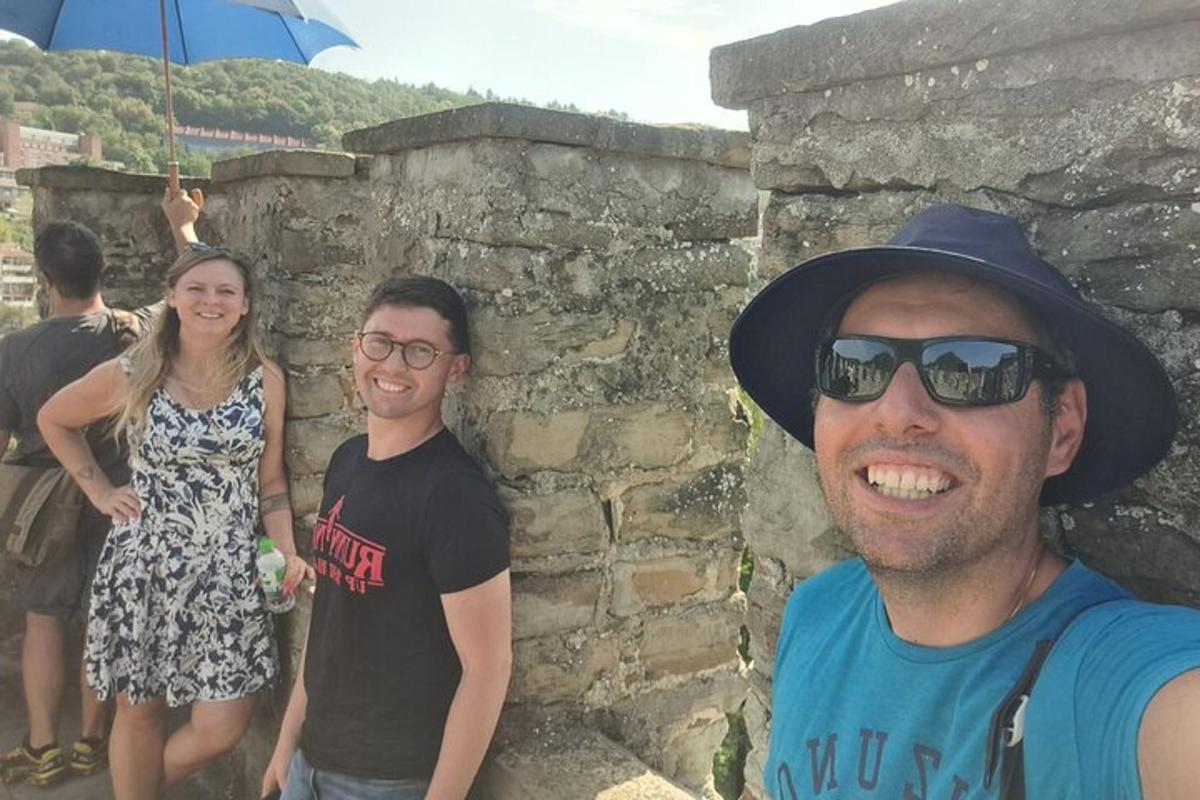 un gruppo di persone in piedi accanto a un muro di pietra