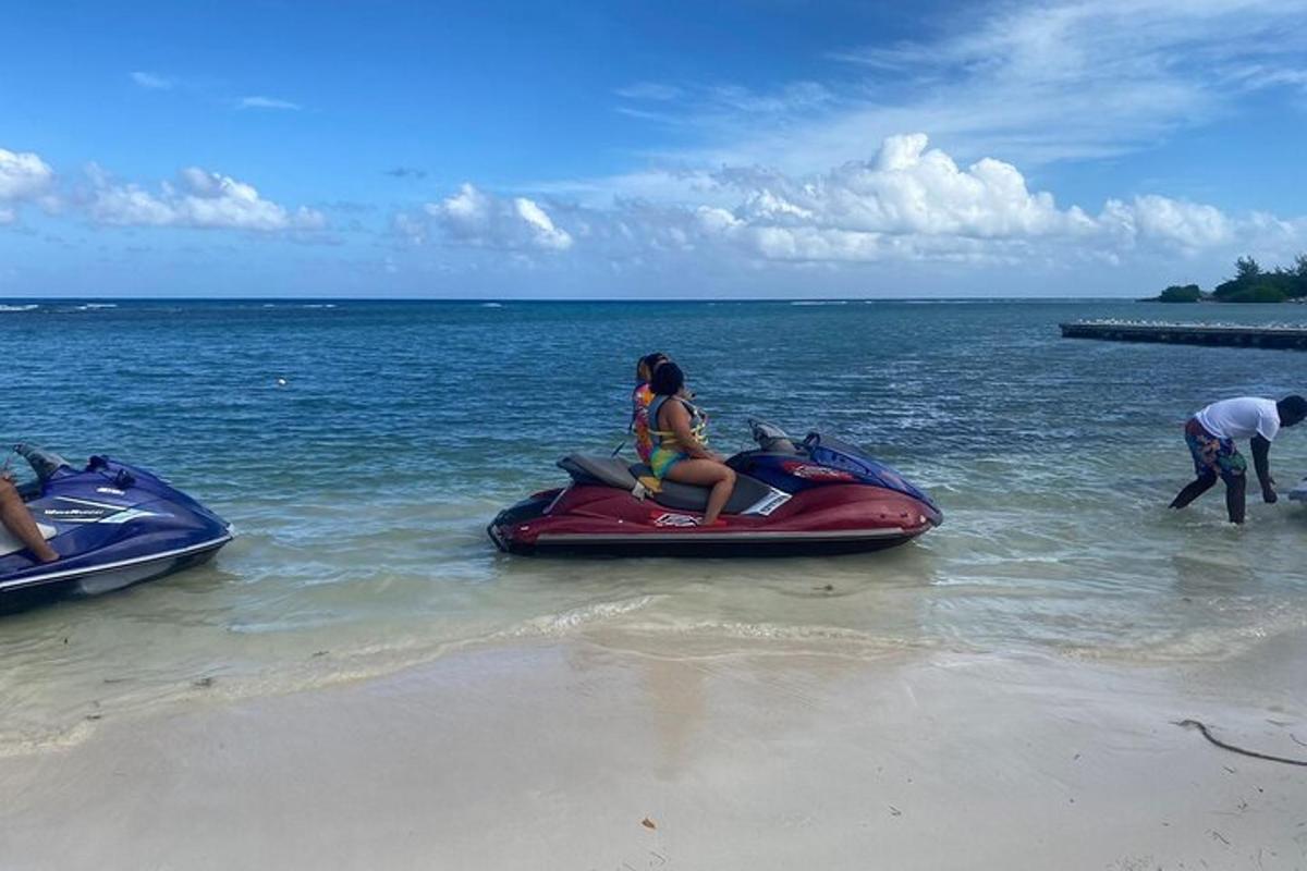dues persones muntant una moto aquàtica a la platja