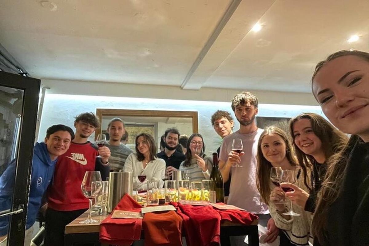 un gruppo di persone in piedi attorno a un tavolo con bicchieri di vino