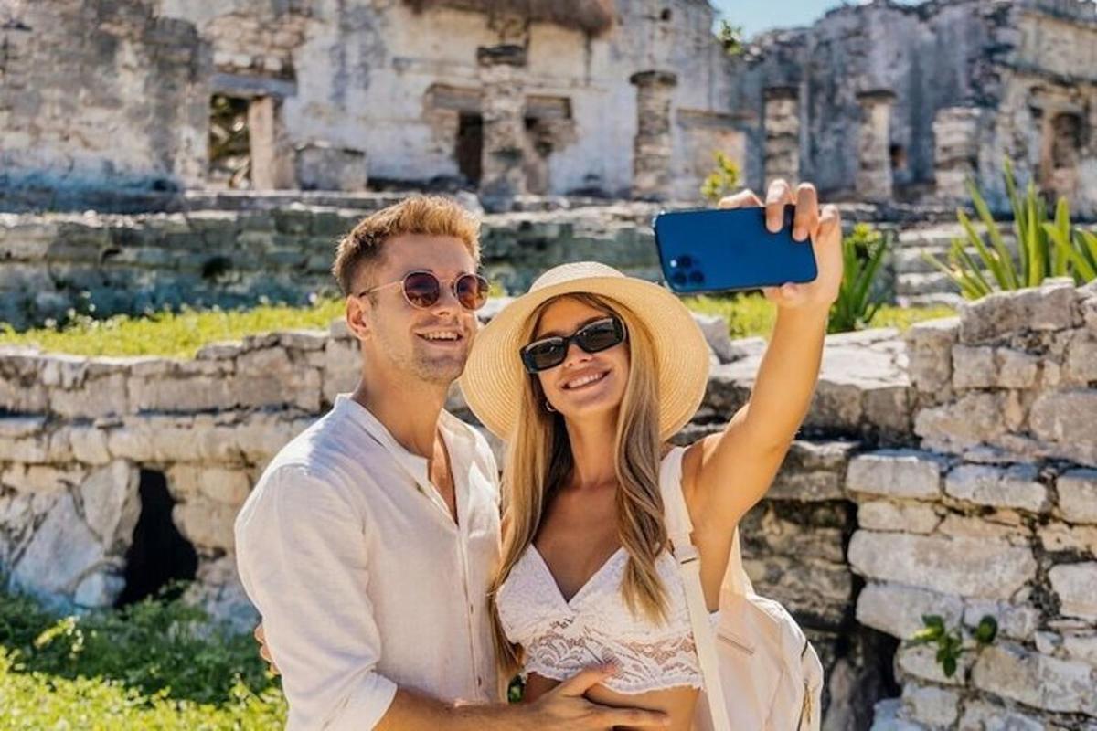 moški in ženska se fotografirata pred ruševinami
