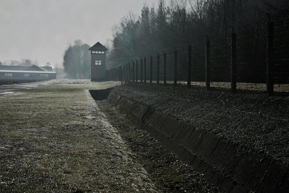 una recinzione con un edificio in mezzo a un campo