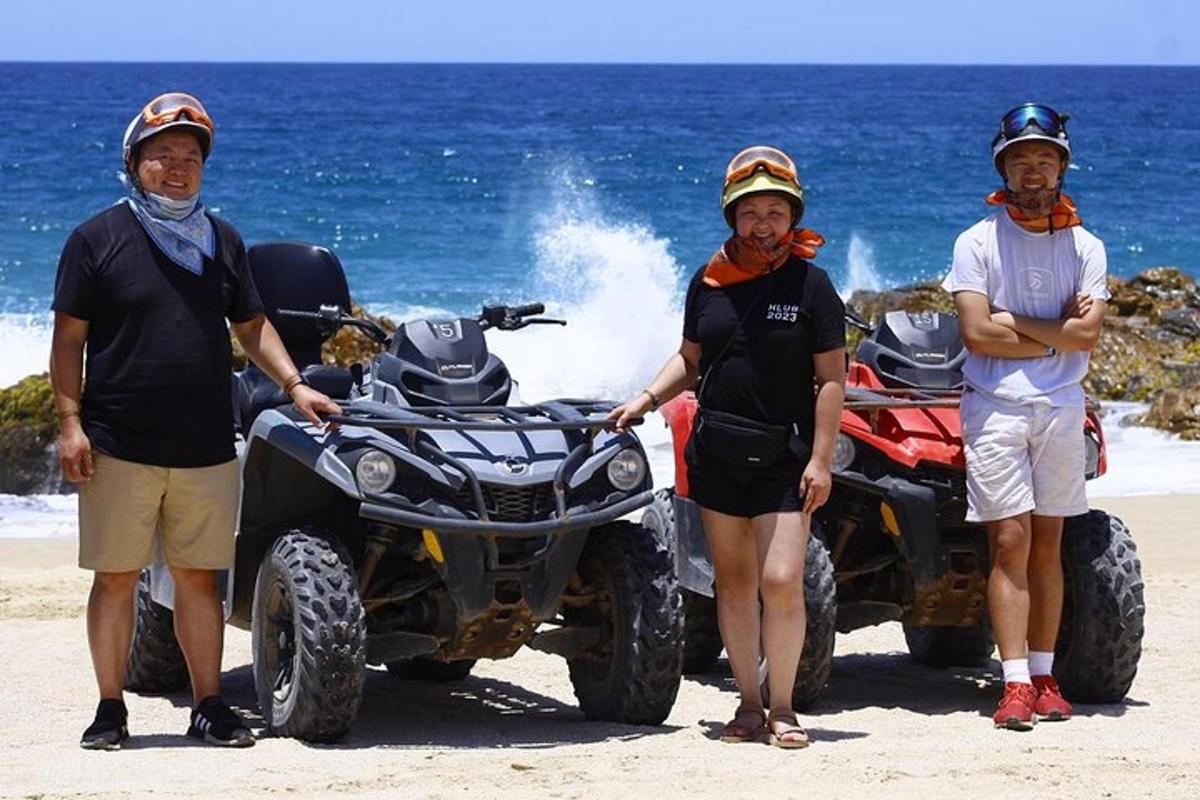 sekumpulan tiga lelaki berdiri di sebelah dua atv di pantai