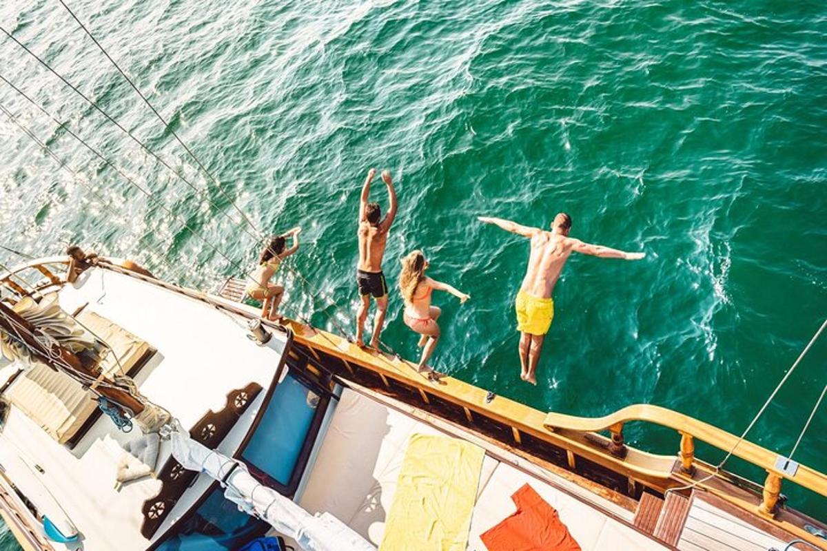 een groep mensen die op een boot in het water springt