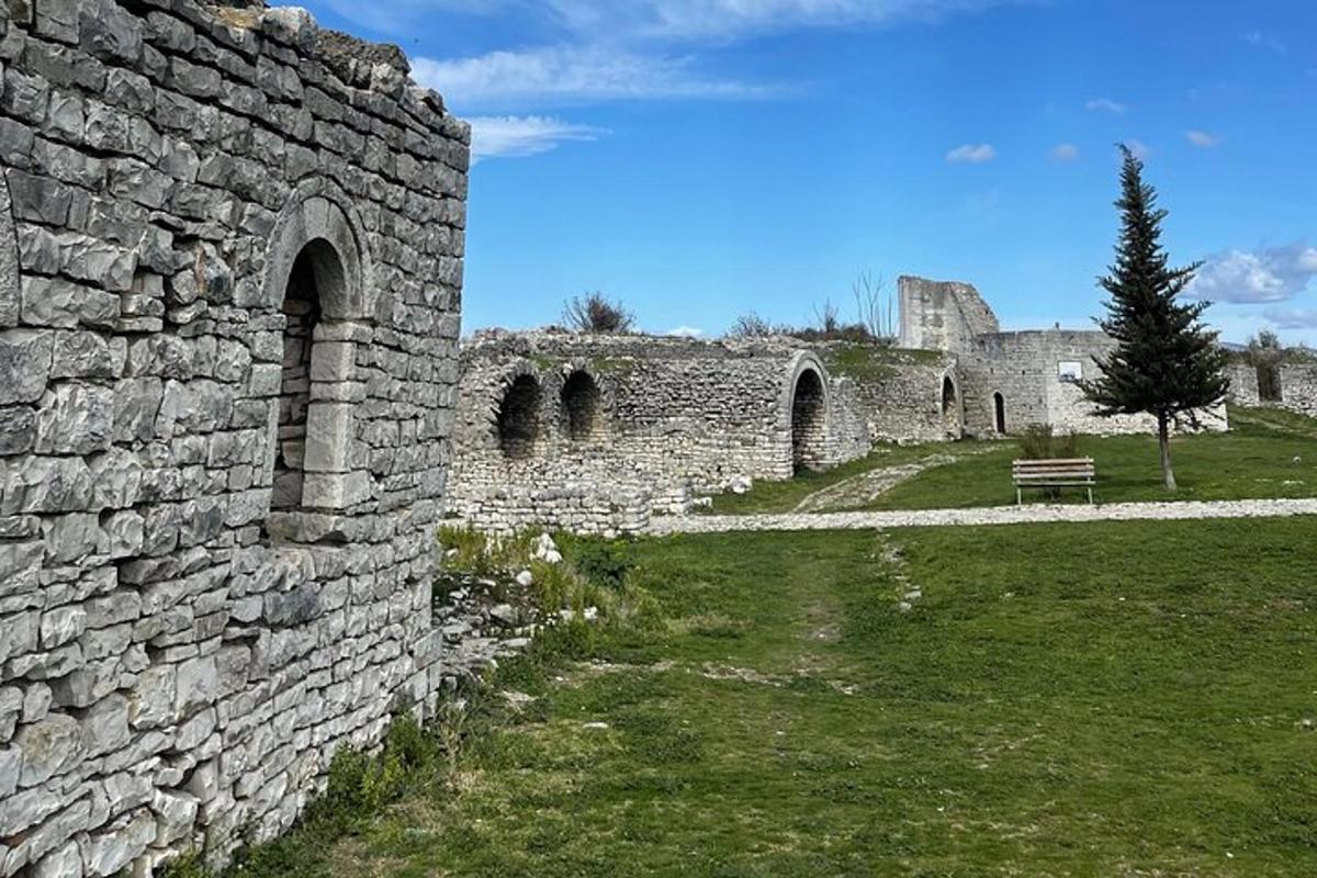 ένα παλιό πέτρινο κτίριο με ένα παγκάκι σε ένα χωράφι